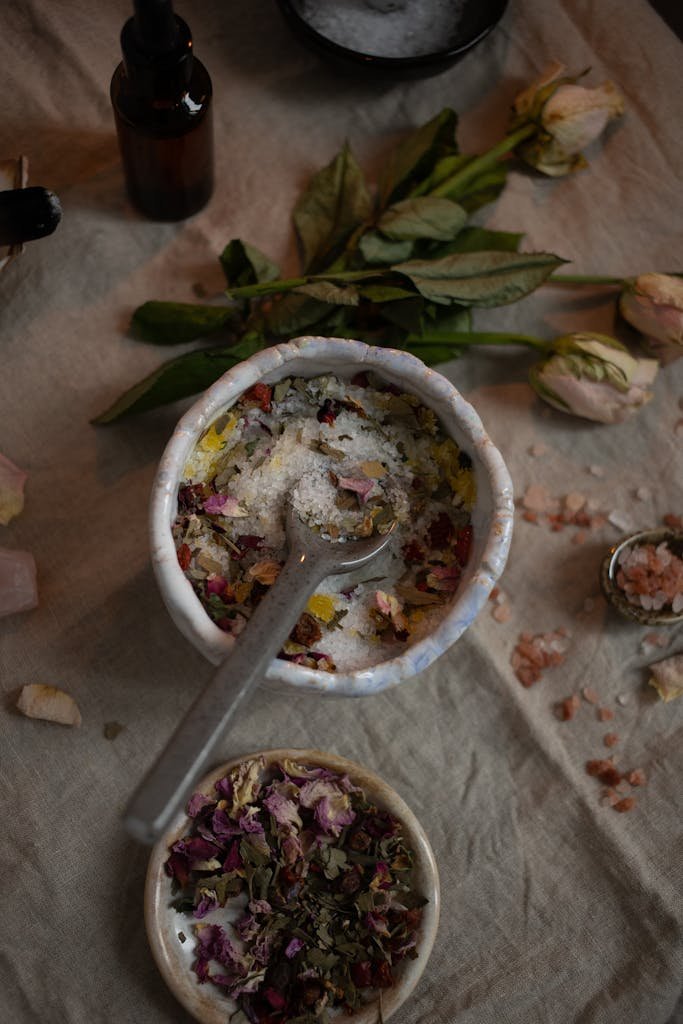 A flat lay of herbal bath salts mixed with dried petals and essential oils, creating a soothing aroma.