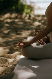 A peaceful  and mindful scene of meditative yoga practice on a sandy beach.