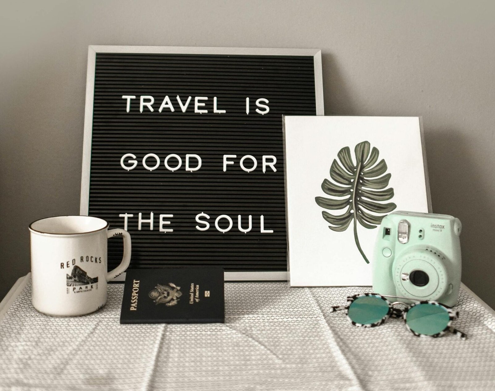 A travel-themed flat lay with a camera, coffee, and motivational quote.