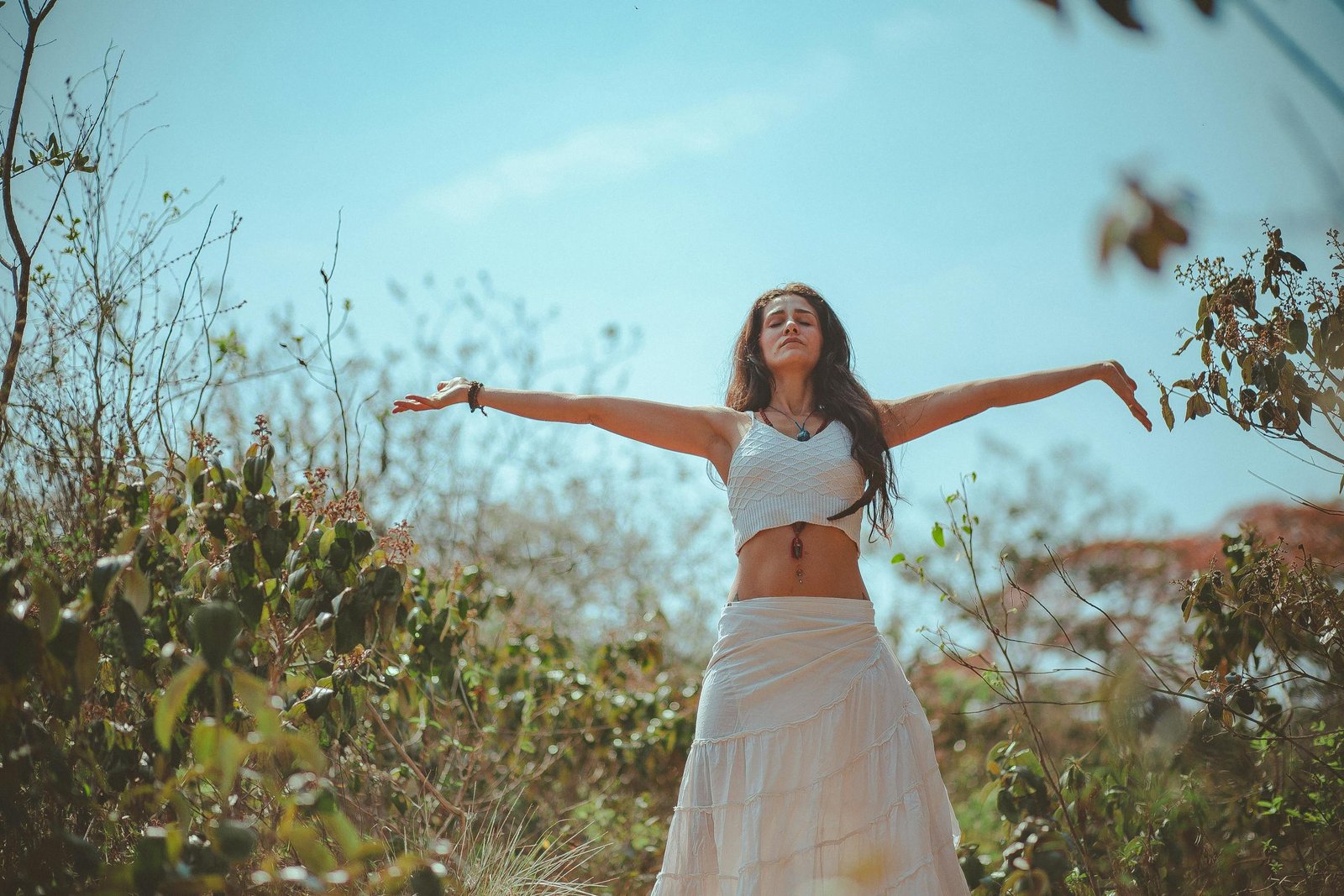 Peaceful scene of a woman meditating outdoors in a sunny summer setting, embodying wellness and tranquility.